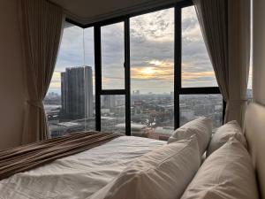 เตียงในห้องที่ Entire apartment near train station with pool & views
