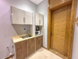a small kitchen with a sink and a microwave at Lavent Park Serviced Apartments - Economic in Jeddah