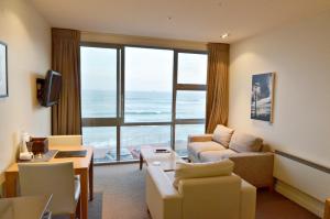 a living room with a view of the ocean at Hotel St Clair in Dunedin