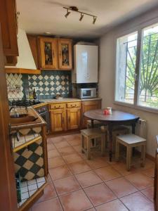 a kitchen with a table and a sink and a table at Maisonnette près du centre ville in Saint-Maximin-la-Sainte-Baume