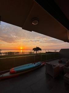 a view of the sunset from the balcony of a house at COMPASS lake view apartment in Mamaia