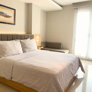 泗水Surabaya River View Hotel的卧室里有一张白色的大床和一扇窗户