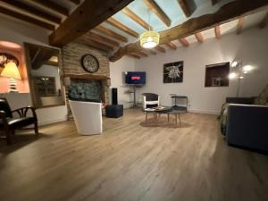 ein Wohnzimmer mit einer Couch und einer Uhr an der Wand in der Unterkunft Évasion à Hainneville in Cherbourg en Cotentin