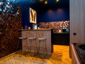 a bar with two stools in front of a counter at Le Voluptueux - Sauna - Jacuzzi - Centre-Ville in Angers