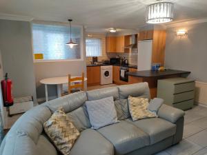 a living room with a couch and a kitchen at San Remo Apartments Blackpool in Blackpool