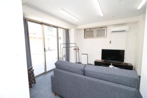 a living room with a couch and a tv at SOKOResort Asakusa in Tokyo