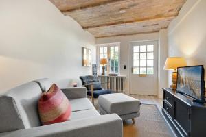 a living room with a couch and a tv at Kleine Heimat Haus Stutenhof Whg 4 in Keitum