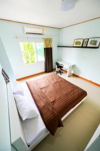 a bedroom with a bed with a desk and a window at PN Home Service @ Suvarnabhumi Airport in Lat Krabang