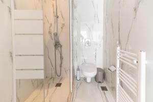 biała łazienka z toaletą i szklanymi drzwiami w obiekcie Stylish spacious apartment in Palaio Faliro (C1) w Atenach +18 zdjęć