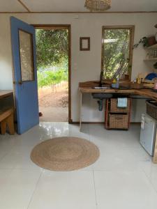 a kitchen with a blue door and a rug on the floor at Cabaña entre parras in Curacaví +6 photos