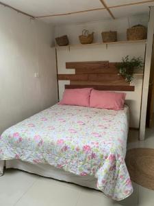 a bedroom with a bed with a pink comforter at Cabaña entre parras in Curacaví