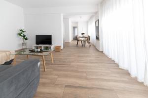 salon z białymi ścianami i drewnianą podłogą w obiekcie Stylish spacious apartment in Palaio Faliro (C1) w Atenach