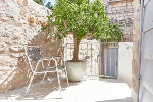 a chair and a tree in front of a gate at Orange Tree House in Vis +22 photos