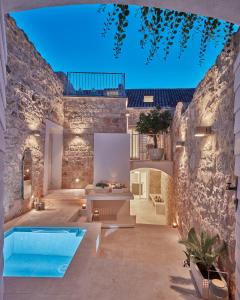 a courtyard with a swimming pool and a house at Orange Tree House in Vis