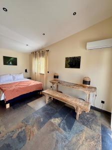 a bedroom with a bed and a wooden bench at Blue Naiade Villa zen and cosy in Étang-Salé