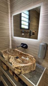 a large stone tub in a bathroom with a mirror at Blue Naiade Villa zen and cosy in Étang-Salé