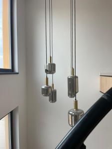a group of three lights hanging from a ceiling at Primaverii 10 by GIA in Caracal