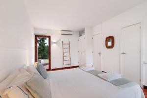 a white room with a bed and a ladder at Apartamento Balaia Praia in Albufeira