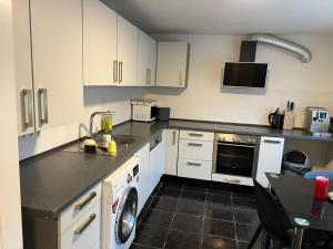a kitchen with white cabinets and a sink and a dishwasher at Natur pur Katharina in Kraiburg am Inn