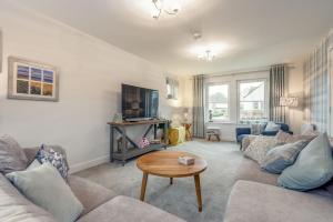 a living room with a couch and a table at Belmont House - Kingsbarns in Kingsbarns