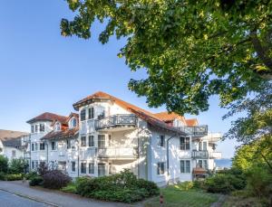 a large white building with a red roof at Ferienwohnung Hafenliebe, Villa Vilmblick mit Meerblick in Lauterbach