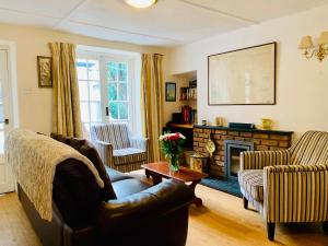a living room with a couch and a fireplace at Maypole Cottages No 10 Broad Street Padstow in Padstow