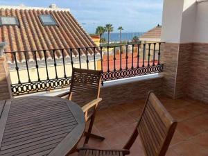 balkon ze stołem i krzesłami i widokiem na ocean w obiekcie Apartamento Club Nautico By Solymar Holiday w mieście Torre del Mar