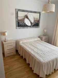 sypialnia z łóżkiem i obrazem na ścianie w obiekcie Apartamento Club Nautico By Solymar Holiday w mieście Torre del Mar