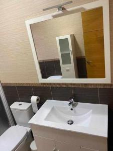 łazienka z umywalką, toaletą i lustrem w obiekcie Apartamento Club Nautico By Solymar Holiday w mieście Torre del Mar +10 zdjęć