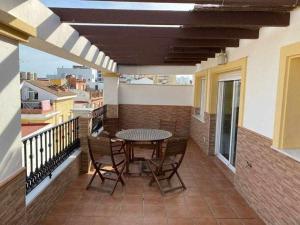 taras ze stołem i krzesłami na balkonie w obiekcie Apartamento Club Nautico By Solymar Holiday w mieście Torre del Mar