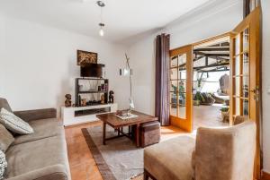 a living room with a couch and a table at Saude Beach House in Costa da Caparica