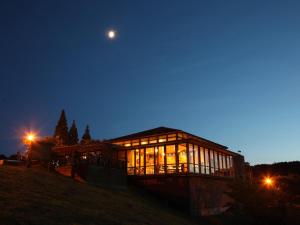 una casa en la cima de una colina por la noche en Matsue Forest Park, en Matsue