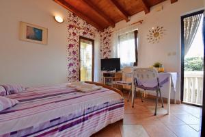 a bedroom with a bed and a table and chairs at Cosy Medulin apartments with terrace in Medulin