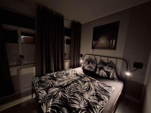 a bedroom with a bed with black and white sheets and pillows at Ferienwohnung im Zschopauer Herzen in Zschopau