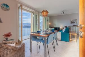 een eetkamer en een woonkamer met een tafel en een bank bij Panorama del Lago in Perledo