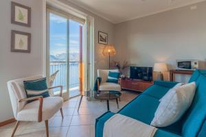 een woonkamer met een blauwe bank en stoelen bij Panorama del Lago in Perledo