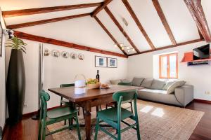 a living room with a wooden table and green chairs at House Corte in Vis +12 photos