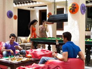 a group of people sitting around a pool table at Novotel Hyderabad Convention Centre in Hyderabad