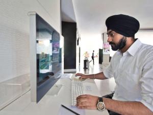 a man sitting at a desk using a laptop computer at Novotel Hyderabad Convention Centre in Hyderabad