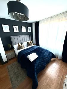 a bedroom with a bed with a blue comforter at Luxury Belfast Stay in Belfast