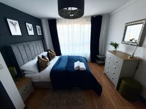 a bedroom with a bed with a blue blanket and a window at Luxury Belfast Stay in Belfast