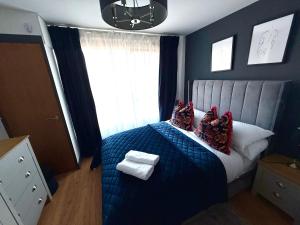 a bedroom with a blue bed with pillows and a window at Luxury Belfast Stay in Belfast