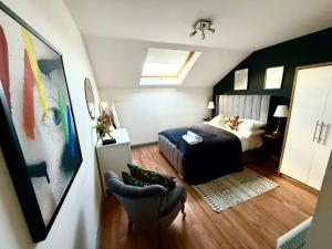 a small bedroom with a bed and a chair at Luxury Belfast Stay in Belfast