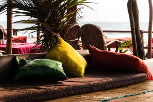 a couch with four colorful pillows on it at Jardim a Mar in Agonda