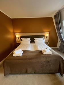 a bedroom with a large bed with two towels on it at Strandperle B&B in Schwielowsee