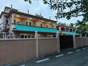 a large house with a fence in front of it at Blue Star Villa in Pointe d'Esny