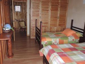 Santa María的住宿－Quinta Galeon Lodge，一间卧室设有两张床,铺有木地板