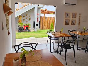 a dining room with tables and chairs and a patio at Pousada Alkamar in Maragogi