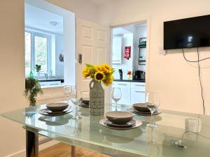 a dining table with glasses and a vase of sunflowers at 4B4B Entire House Sleeps 11 Driveway Parking near Coventry University and City Centre in Coventry
