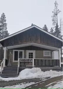 una casa de madera con un cartel delante en North Frontier 1-bedroom cabin, en Saariselkä